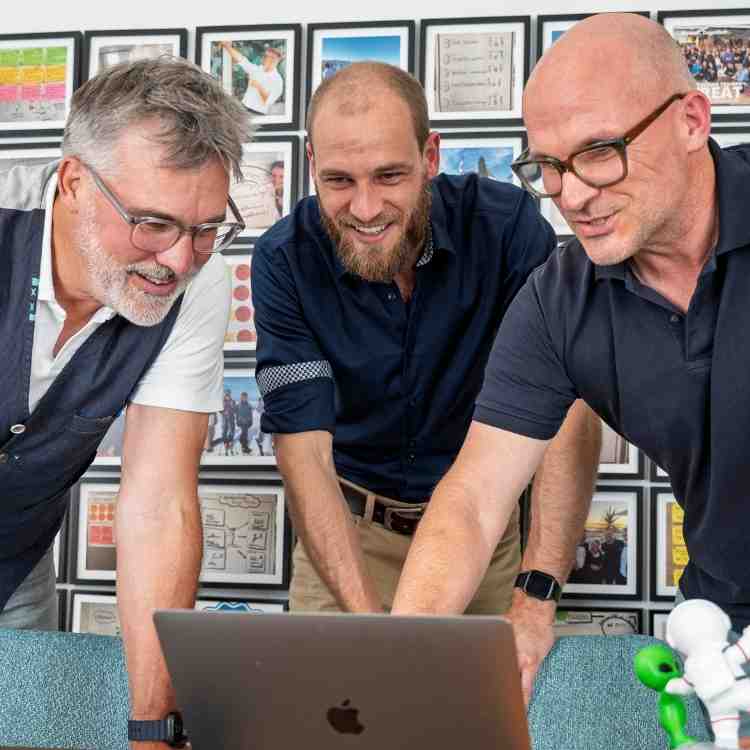Die drei Gründer des KI Hafen am Laptop im Büro in Zug